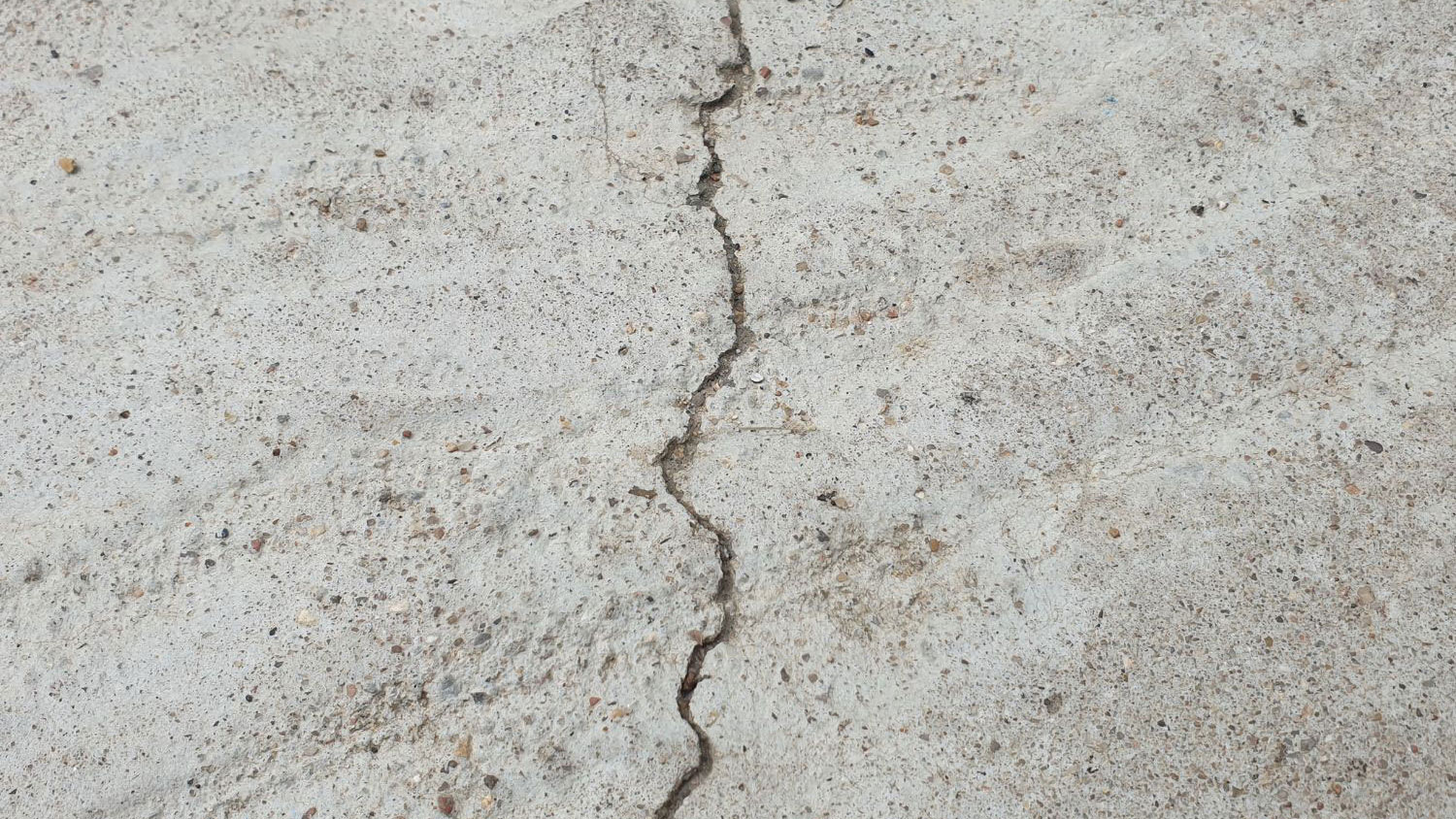 Concrete foundation wall with a prominent vertical crack extending across the surface.